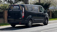a black van is parked on the side of the road